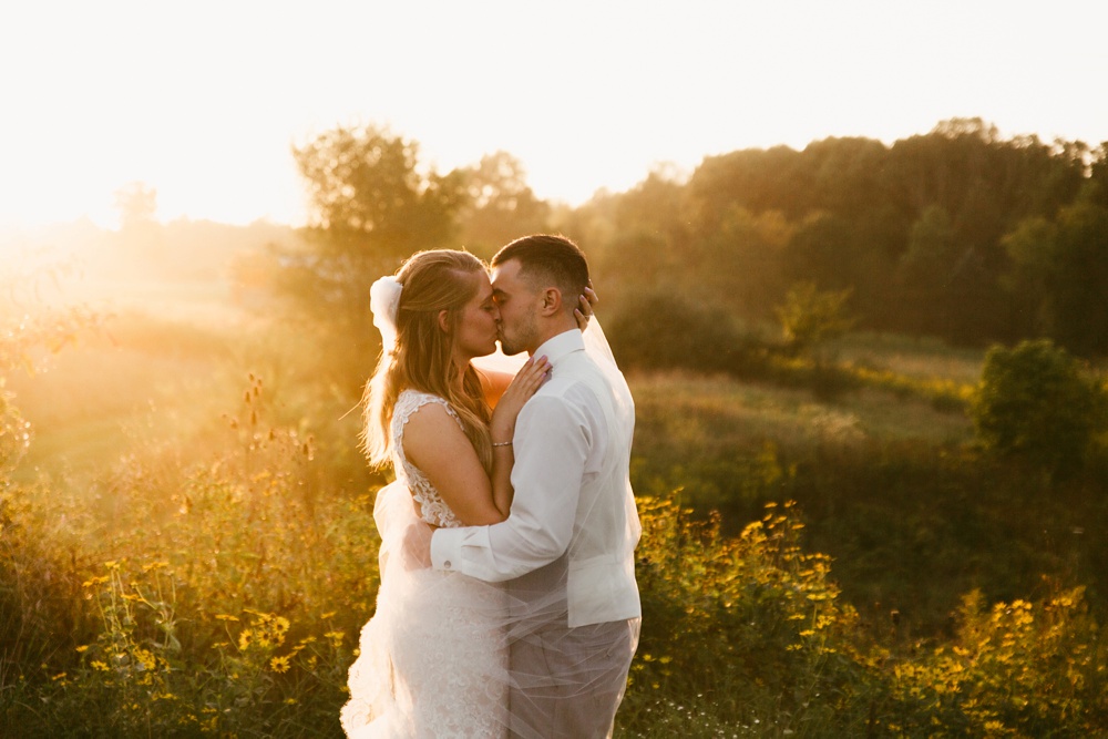 bride and groom kissing at sunset at metea county park fall wedding