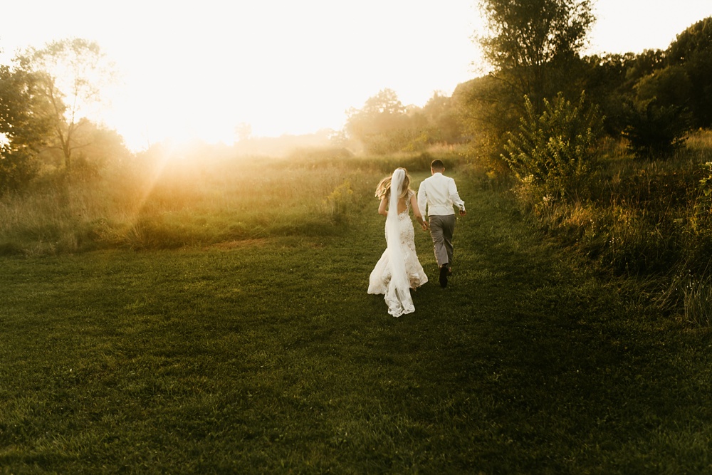 bride and groom holding hands at sunset at metea county park fall wedding