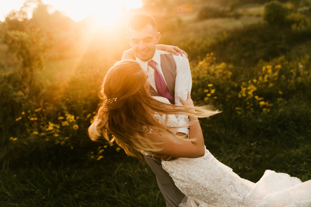 groom holding bride at sunset at metea county park fall wedding