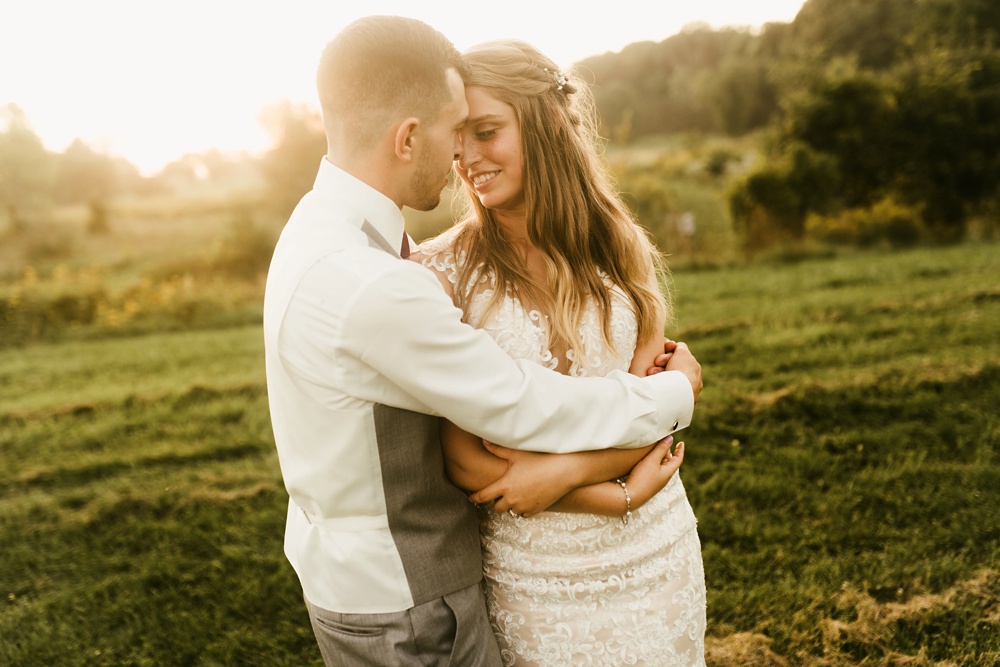 bride adnd groom hugging at sunset at metea county park fall wedding