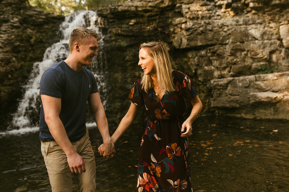 couple holding hands by waterfall at france park engagement session