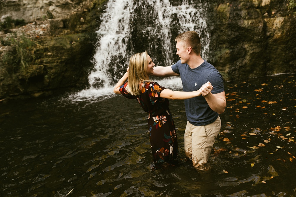 couple laughing by waterfall at france park engagement session