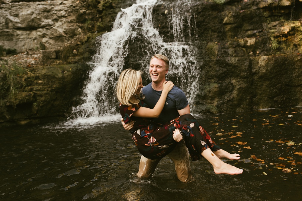 man holding fiance by waterfall at france park engagement session
