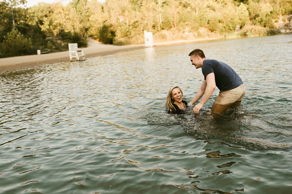man dropping fiance into water at france park engagement session