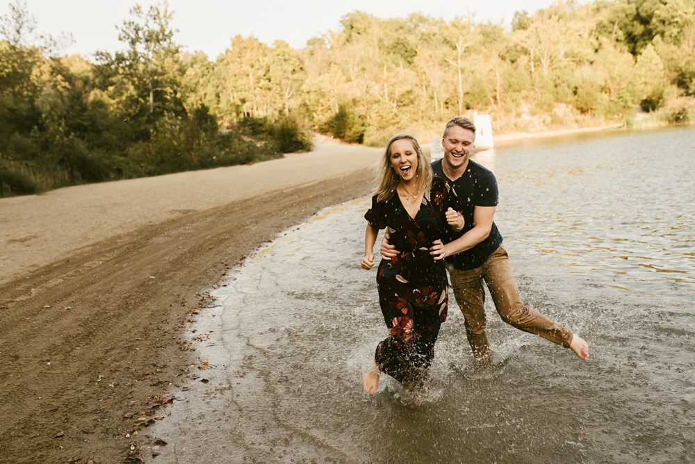 couple running through water at france park engagement session