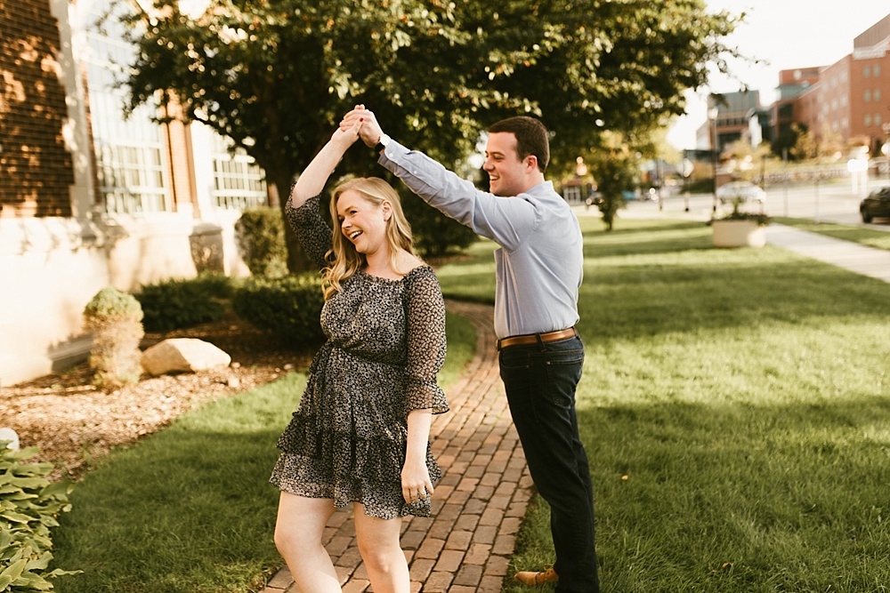 man twirling fiance at downtown south bend engagement session