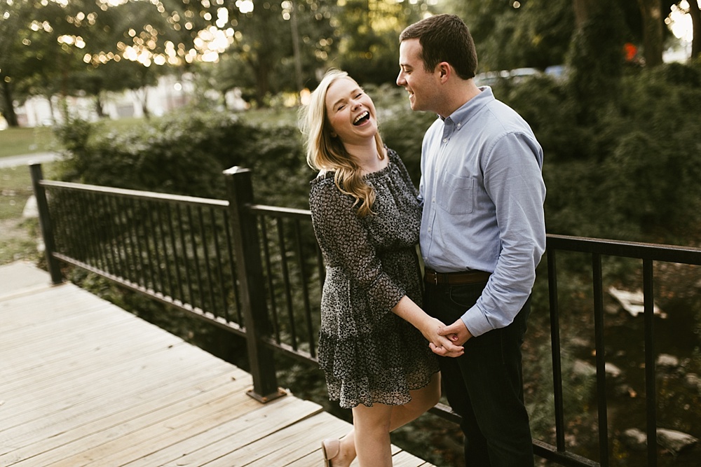 couple laughing on bridge at downtown south bend engagement session