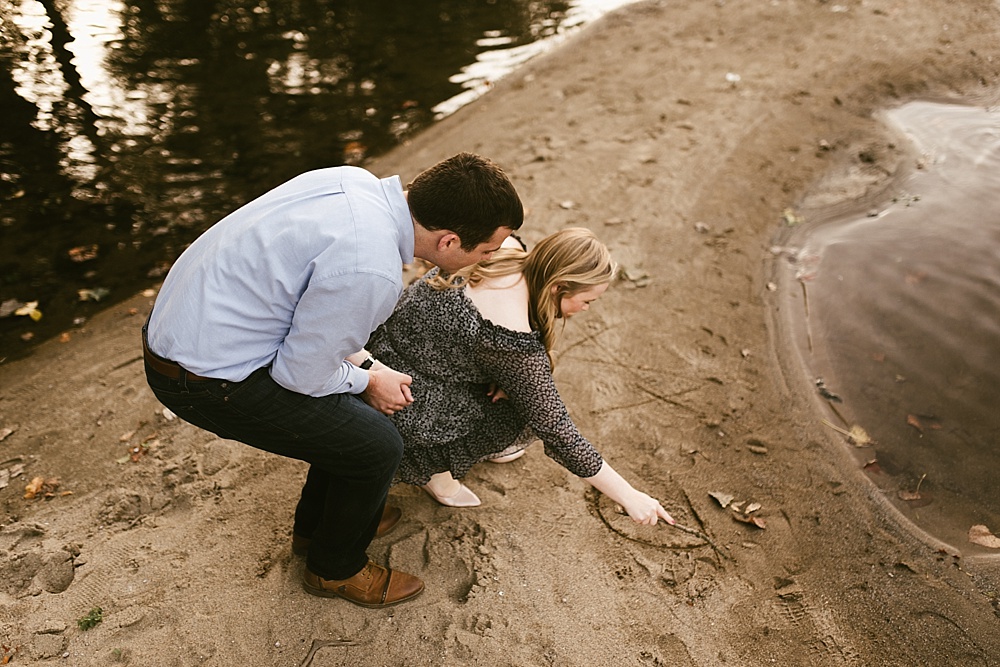 couple playing in sand at downtown south bend engagement session