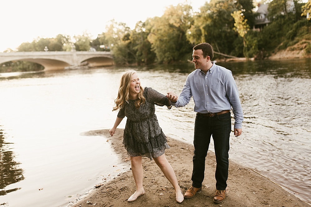 couple holding hands by pond at downtown south bend engagement session