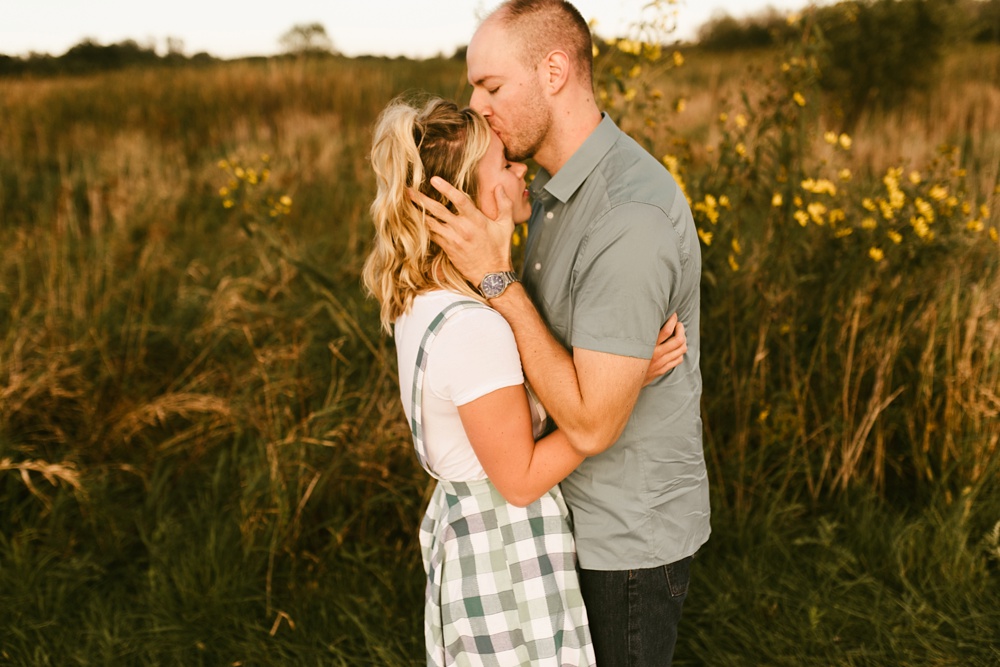 couple kissing by field at eagle marsh nature preserve engagement session