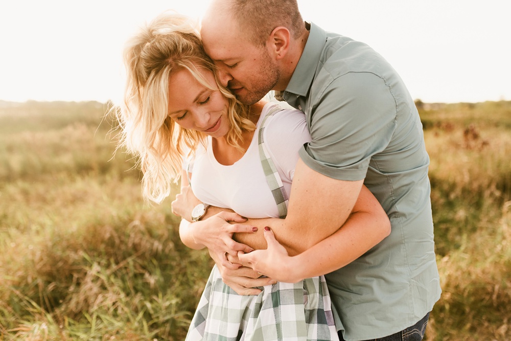 couple kissing in sunlight at eagle marsh nature preserve engagement session
