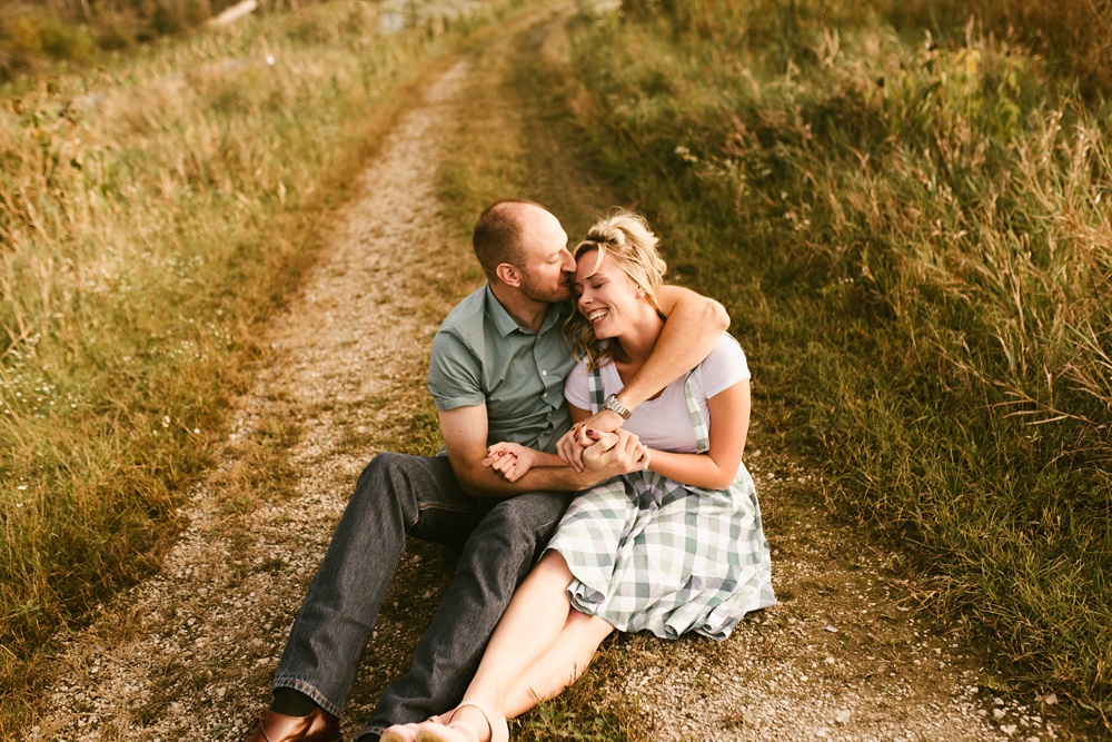 couple hugging by field at eagle marsh nature preserve engagement session