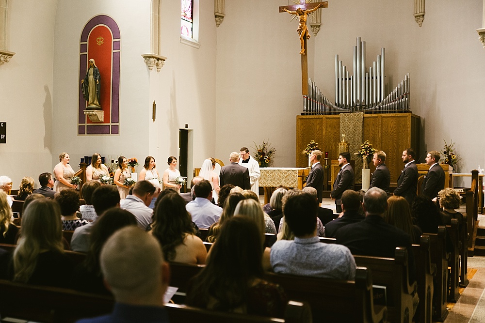 bride, groom, priest and guests at precious blood catholic church wedding