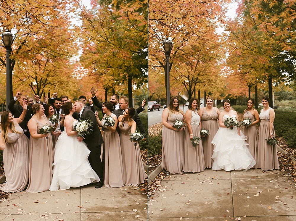 bride and groom kissing with wedding party at headwaters park fall wedding
