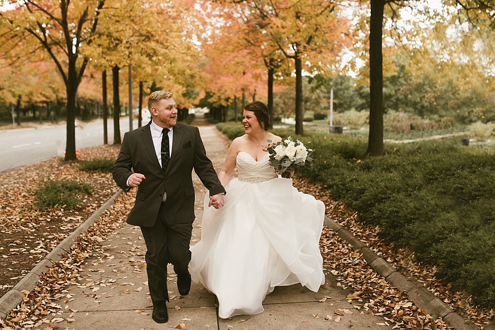 bride and groom holding hands at headwaters park fall wedding