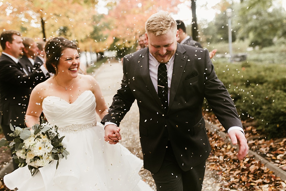 couple holding hands and laughing at headwaters park fall wedding