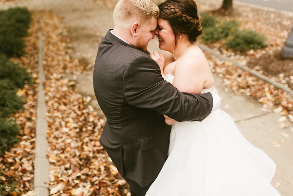 bride and groom hugging and smiling at each other at headwaters park fall wedding