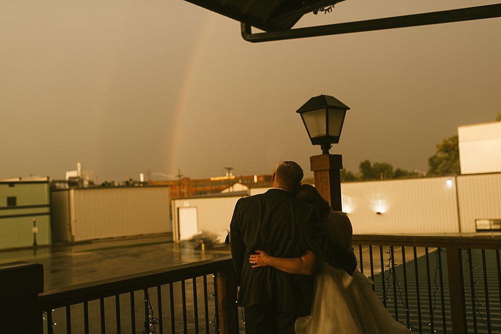 bride and groom watching rainbow at bergstaff place fall wedding
