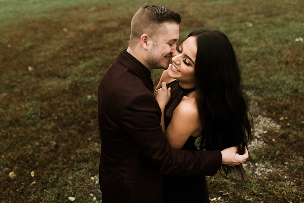 couple smiling and hugging at sunrise eagle marsh engagement session