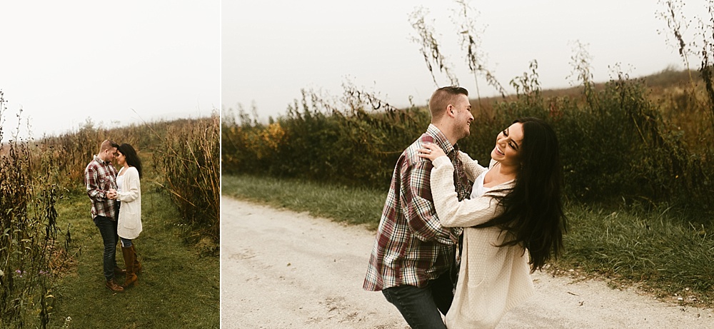 couple hugging next to field at sunset at sunrise eagle marsh engagement session