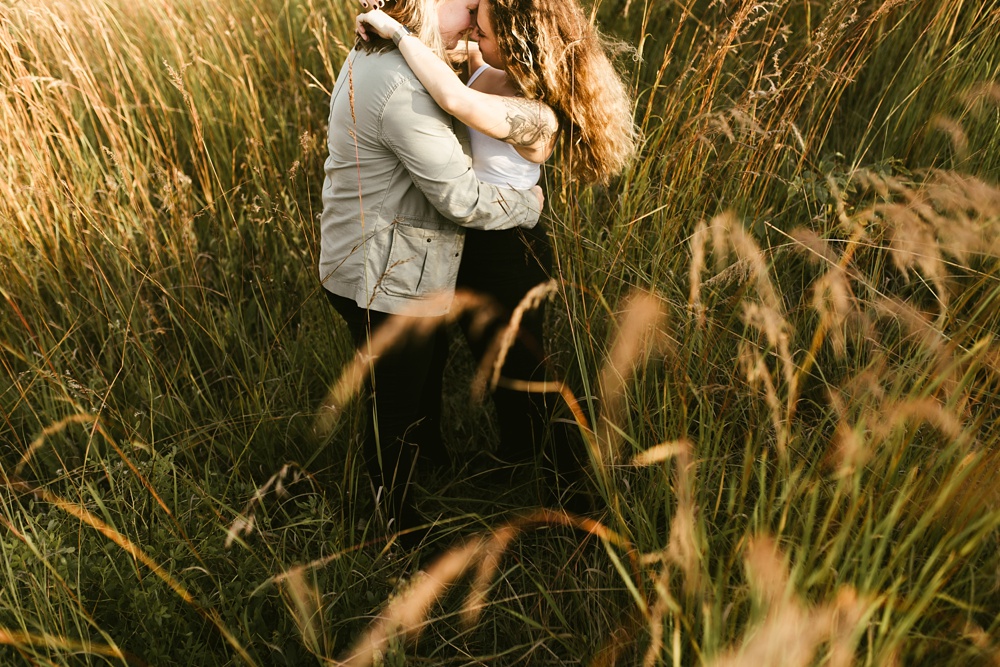 couple hugging in field at coffee creek watershed preserve engagement session