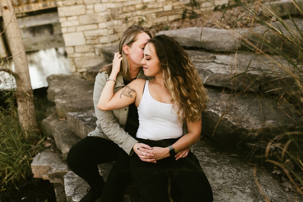 couple hugging on steps at coffee creek watershed preserve engagement session