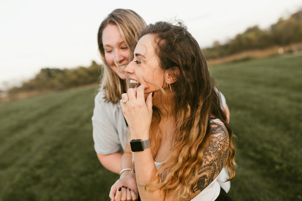 couple laughing in field at coffee creek watershed preserve engagement session