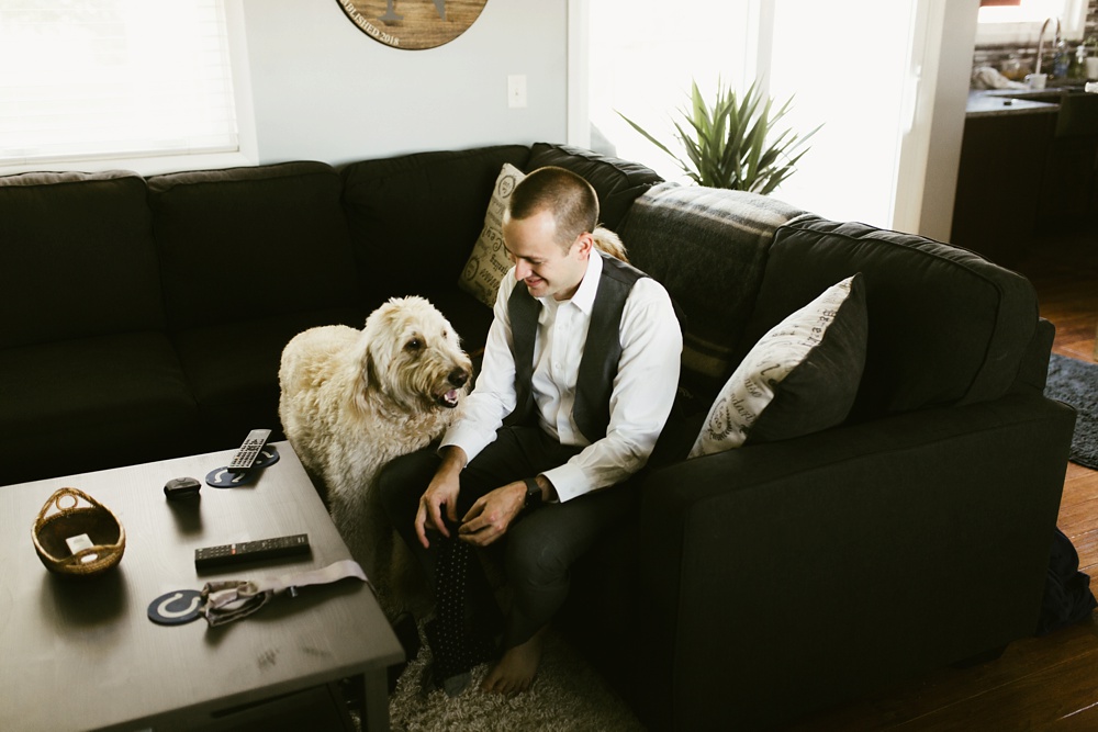 groom with dog before ceremony at indiana wesleyan fairmount campground wedding