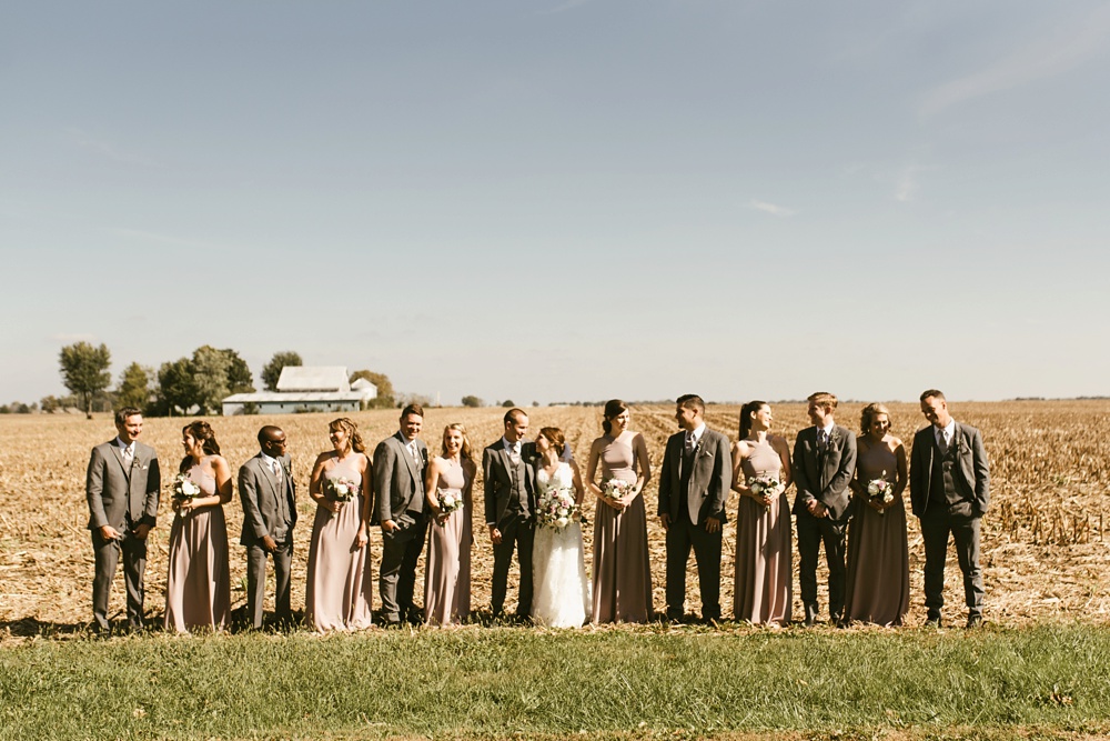 wedding party in gray tuxes and blush dresses smiling at indiana wesleyan fairmount campground wedding