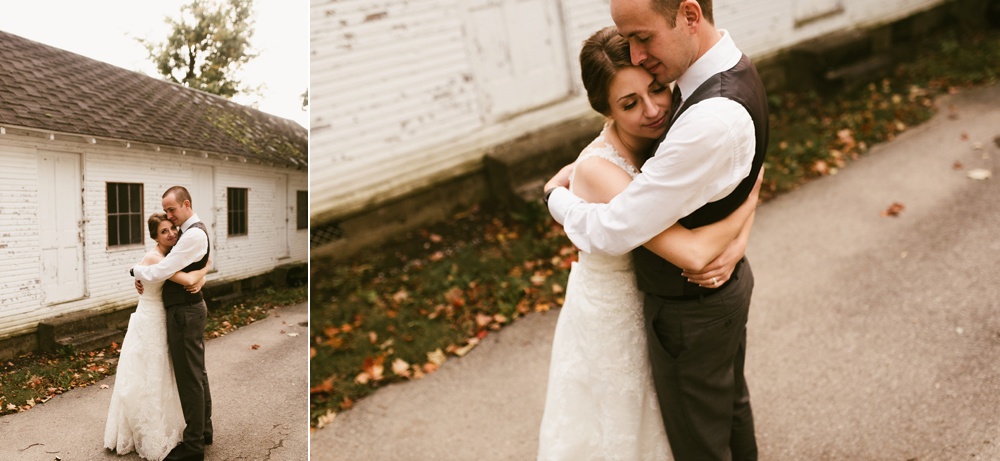 couple hugging in fall leaves at indiana wesleyan fairmount campground wedding