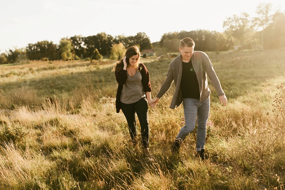 couple holding hands in field at golden hour fort wayne autumn engagement session