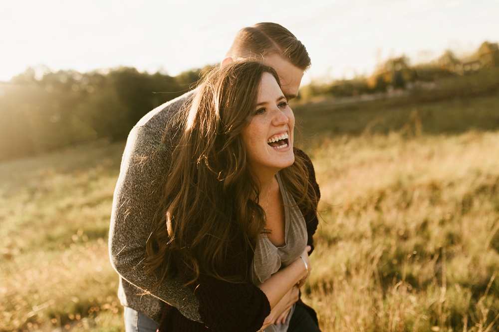 couple laughing in field in field at golden hour fort wayne autumn engagement session