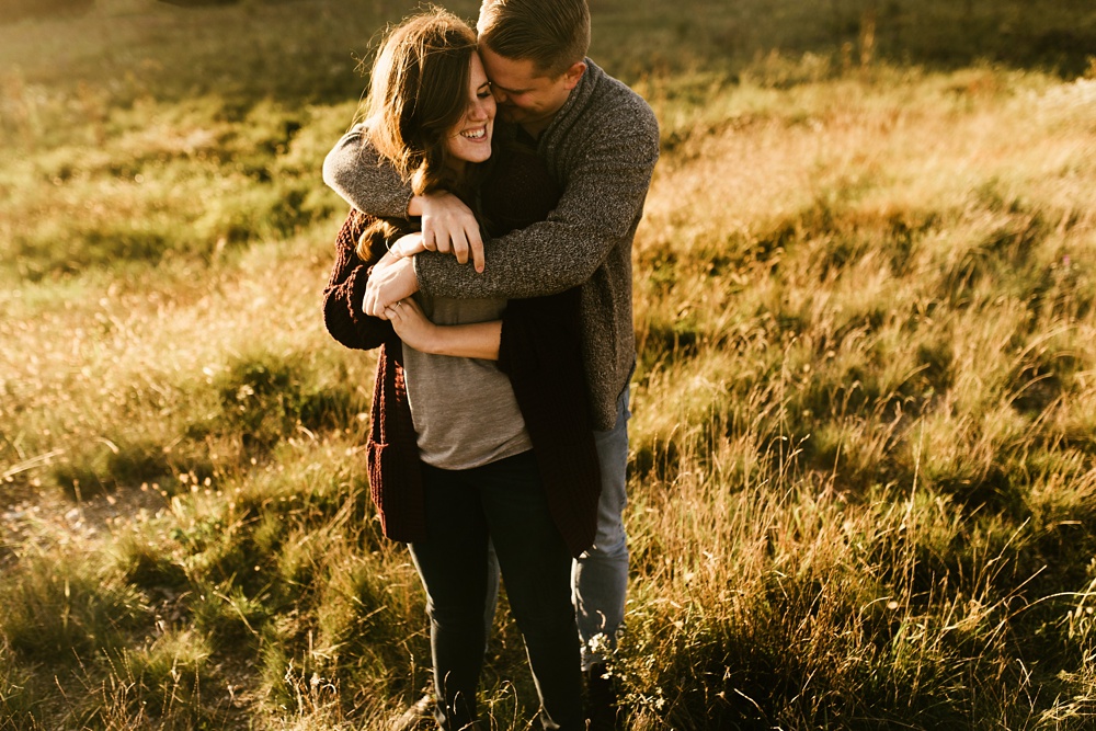 couple hugging in field at golden hour fort wayne autumn engagement session