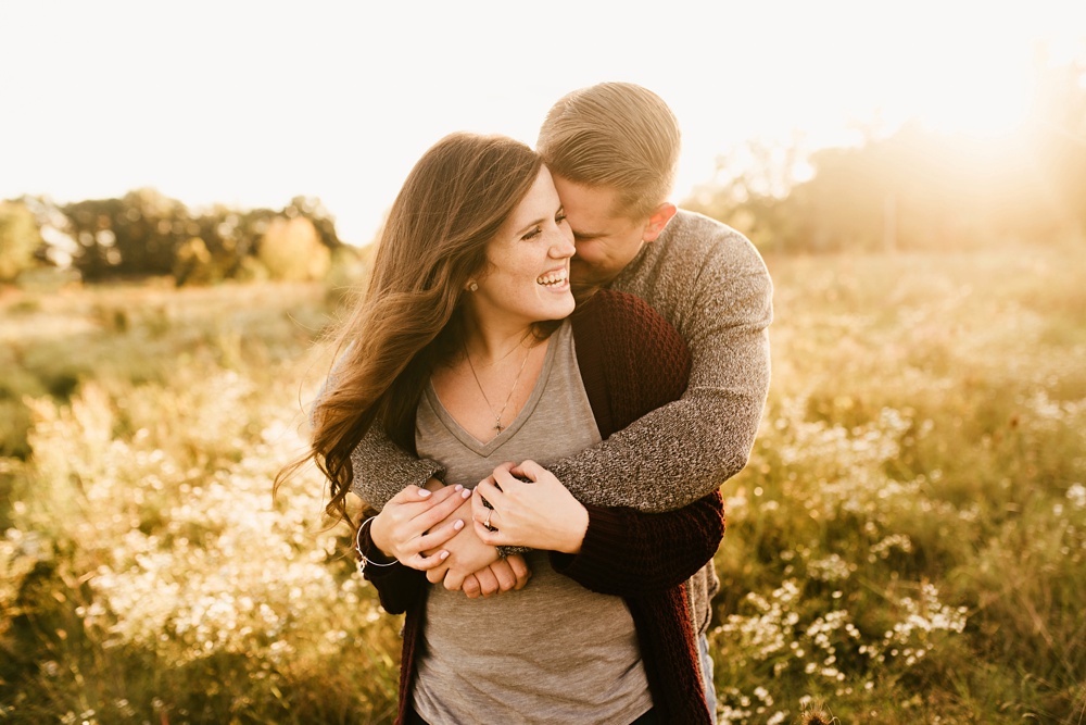 couple smiling in field at golden hour fort wayne autumn engagement session