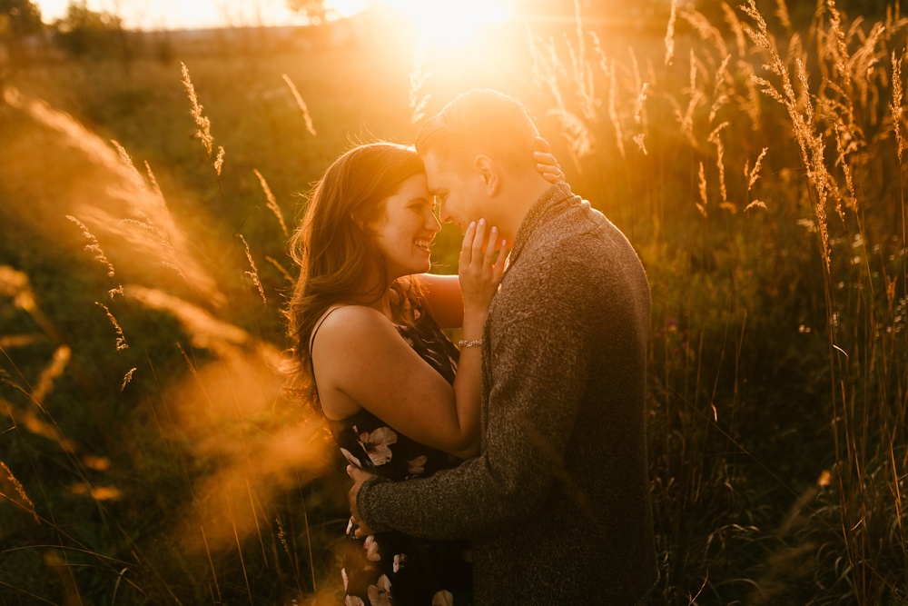couple hugging at golden hour in field at golden hour fort wayne autumn engagement session