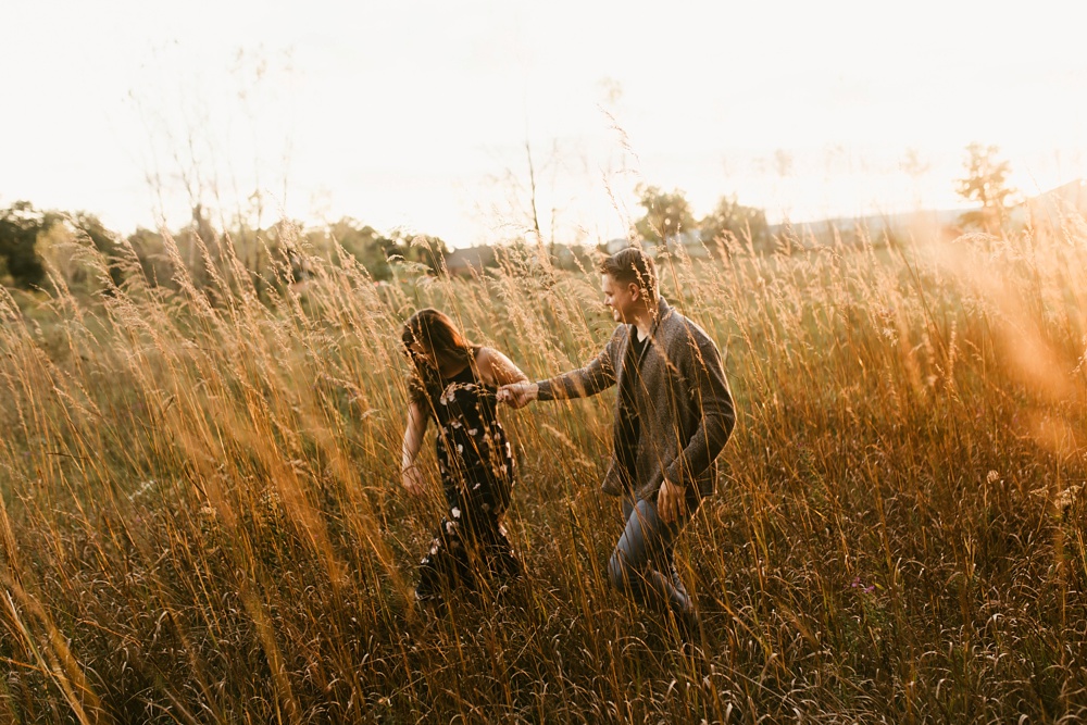 couple holding hands in field at golden hour fort wayne autumn engagement session