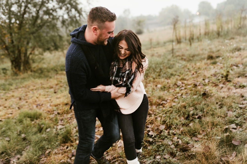 couple hugging in field at auburn sunrise engagement session