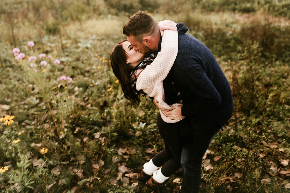 couple kissing in field at auburn sunrise engagement session