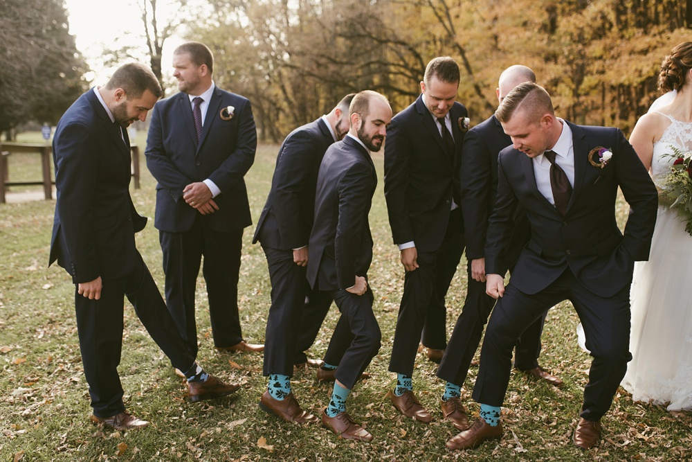groomsmen showing off socks at green bay pamperin park rock garden wedding