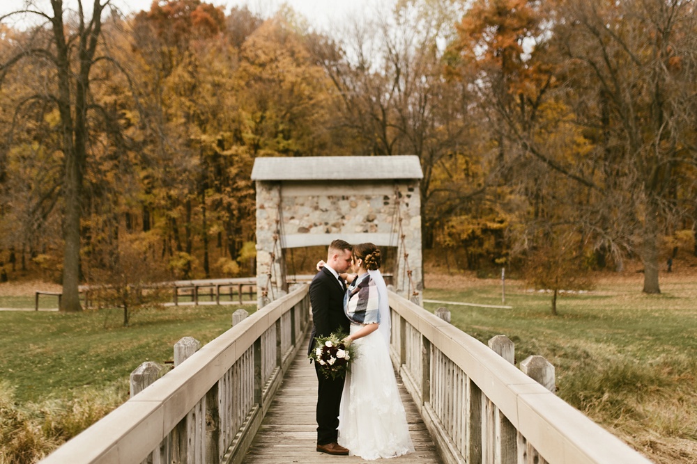 bride and groom hugging on bridge at green bay pamperin park rock garden wedding
