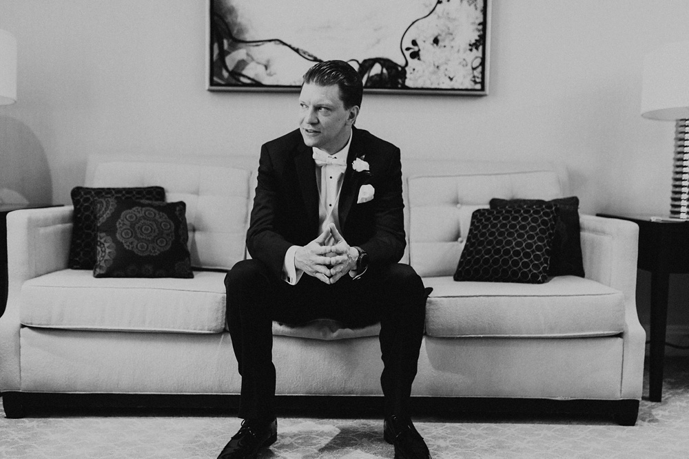 groom sitting on couch before wedding at skydeck willis tower chicago wedding