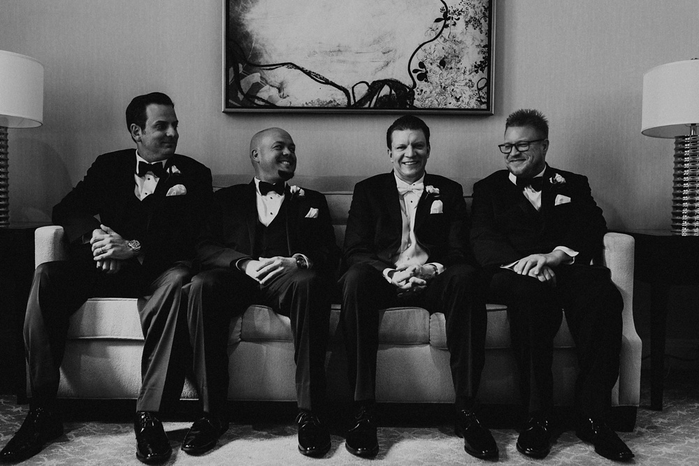 groomsmen sitting on couch at skydeck willis tower chicago wedding
