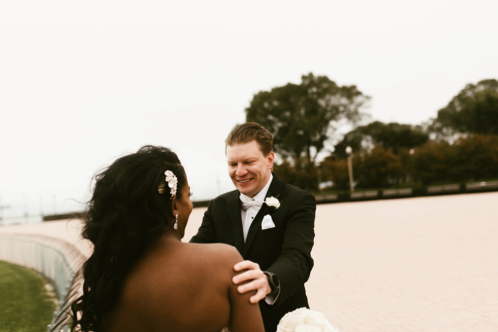 groom smiling at first look ceremony buckingham fountain chicago
