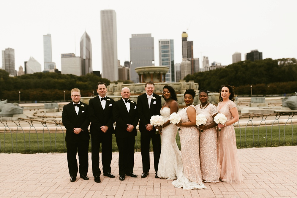wedding party smiling at buckingham fountain chicago