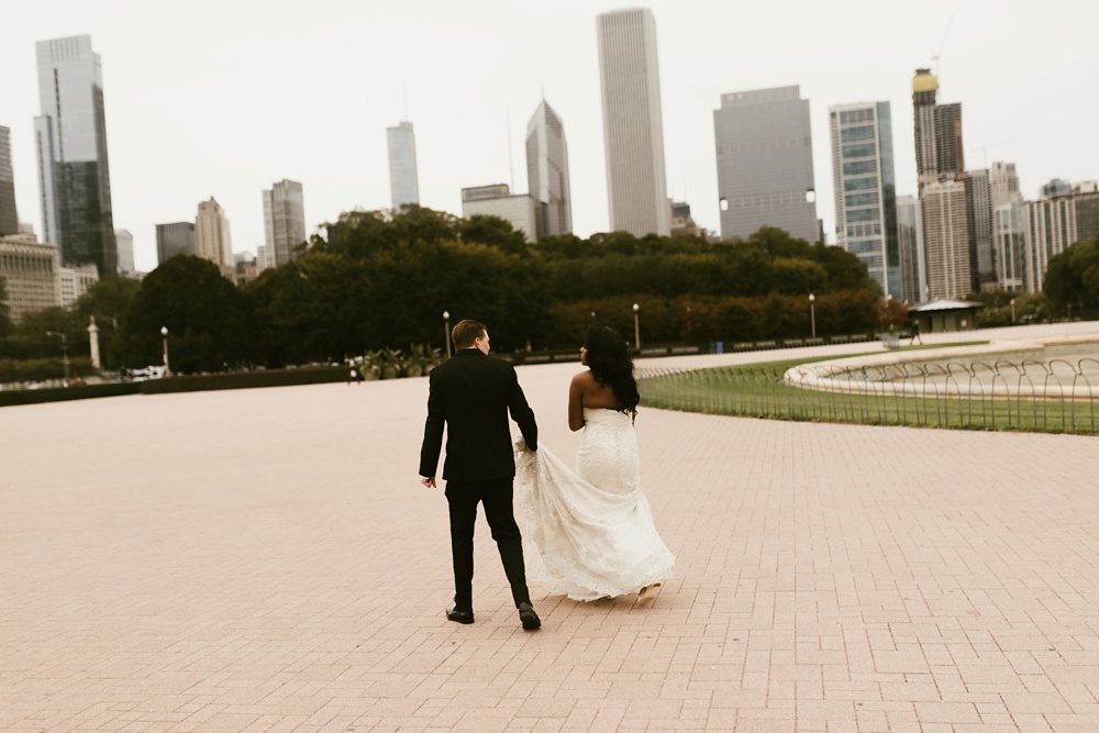 bride and groom walking at buckingham fountain chicago