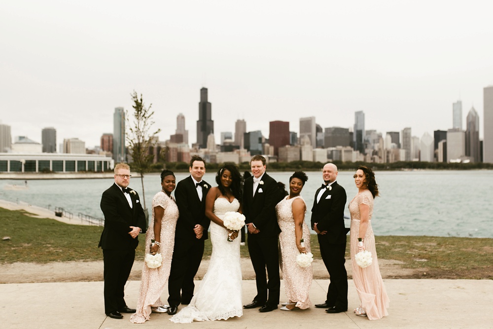 wedding party smiling in front of skyline buckingham fountain chicago