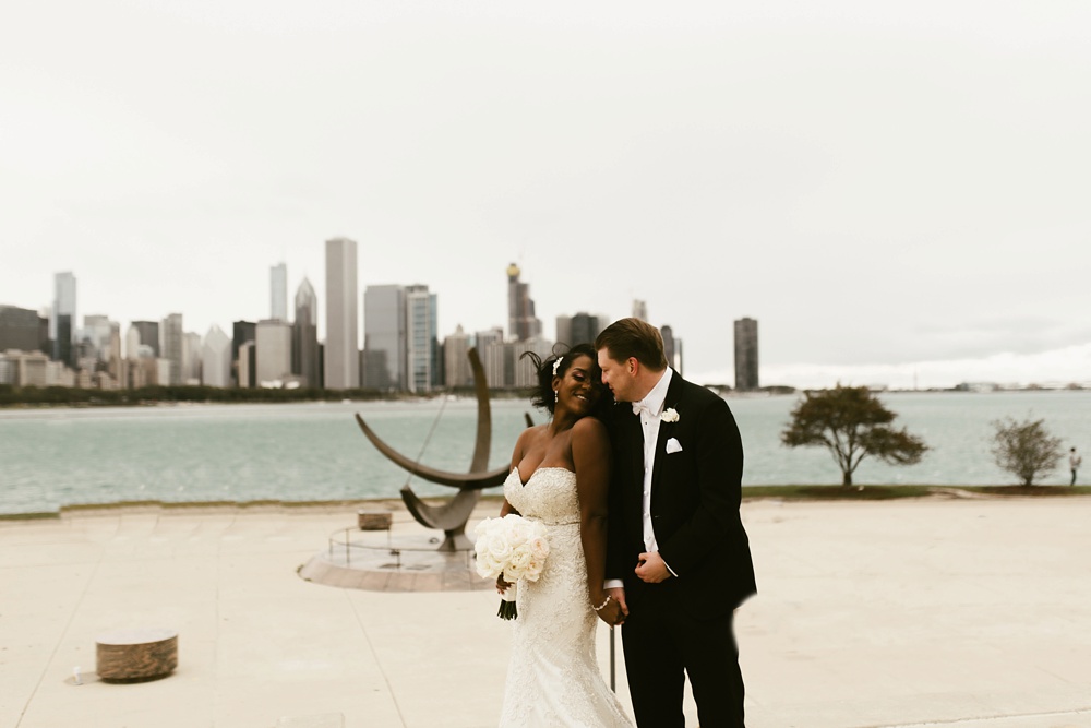 bride and groom holding hands next to shoreline buckingham fountain chicago