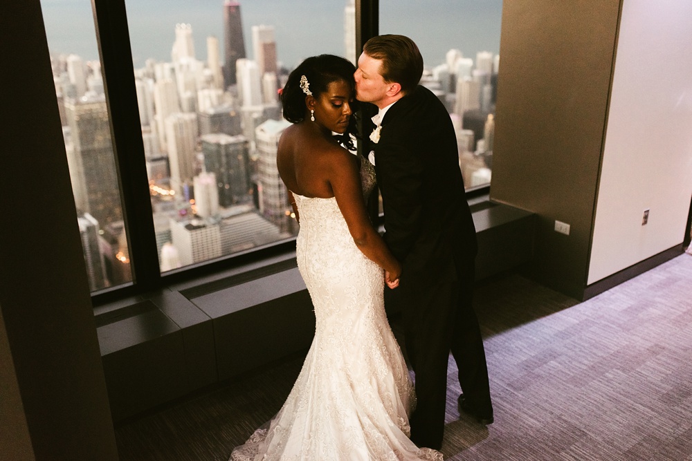 groom kissing brides forehead at skydeck willis tower wedding