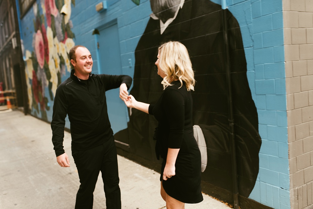 couple dancing next to mural at downtown fort wayne engagement session
