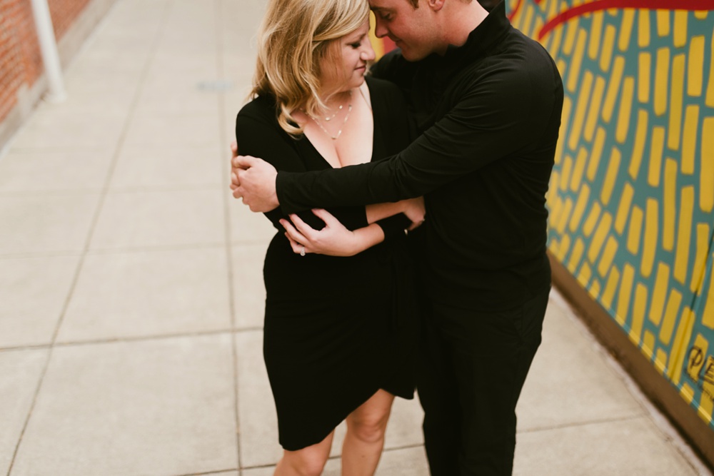 couple holding in mural alley at downtown fort wayne engagement session